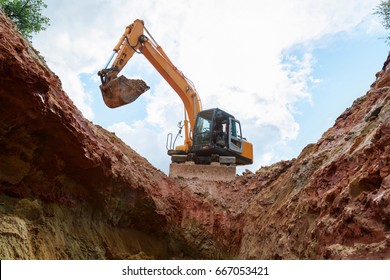 Excavator Digging A Trench. Work On The Construction Site.