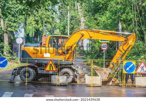 Excavator\
digs a hole on the construction site\
territory.