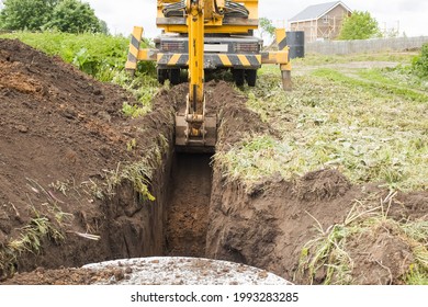 An Excavator Digs A Trench For Laying A Water Pipe