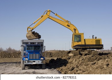 Excavator And Dumptruck On Construction Site