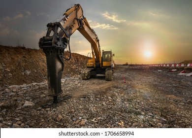 Excavator with hydraulic hammer on road construction works