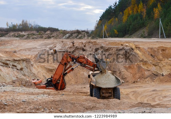 Excavator loading sand\
into dumper truck. Quarry for the extraction of minerals. Ladle.\
Special equipment