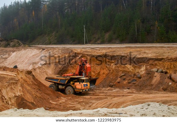 Excavator loading of sand, ore on the dump\
truck. The big Mining dump truck is mining machinery, or mining\
equipment to transport sand from\
open-pit