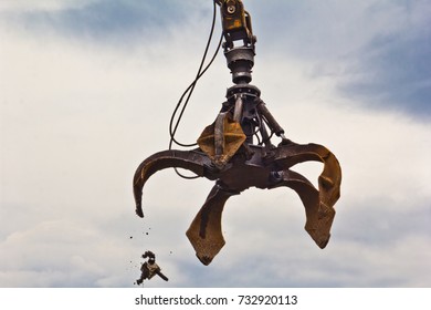 Excavator Is Loading Scrap Metal Junk Into A Bin At A Garbage Dump Or Recycling Center.