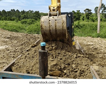 An excavator is loading soil into a dump truck to move the soil. It is a machine of human capital in the construction industry. or farming