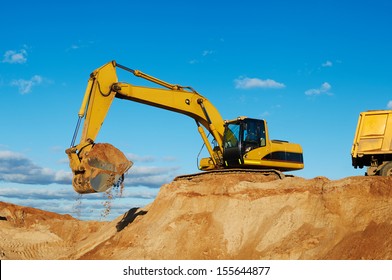 Excavator Machine Loading Dumper Truck At Sand Quarry