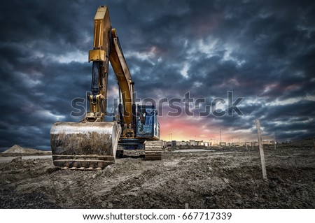Excavator machinery at construction site, sunset in background.