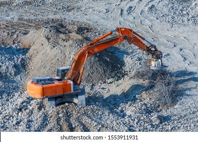Excavator with a magnet on the boom for loading metal waste cargo
