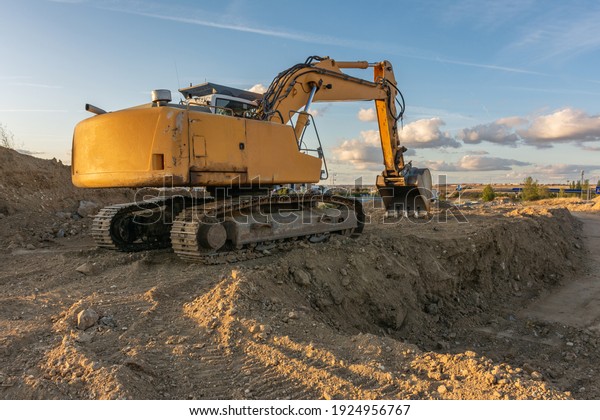 Excavator\
moving dirt and sand at a construction\
site