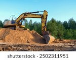 Excavator on earthmoving. Open-pit mining. Backhoe dig sand, ground in quarry. Heavy construction equipment on excavation on construction site. Excavator on groundwork, foundation. Road construction.