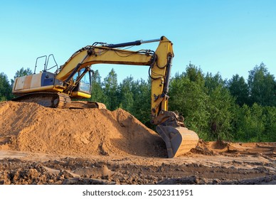 Excavator on earthmoving. Open-pit mining. Backhoe dig sand, ground in quarry. Heavy construction equipment on excavation on construction site. Excavator on groundwork, foundation. Road construction.