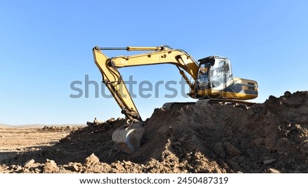 Excavator on earthmoving. Open-pit mining. Backhoe dig ground in quarry. Heavy construction equipment on excavation on construction site. Excavator on groundwork foundation. Road construction.
