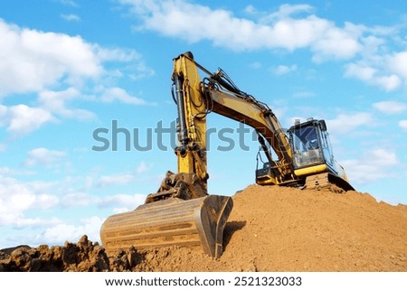 Excavator on earthmoving. Open-pit mining. Backhoe dig sand, ground in quarry. Heavy construction equipment on excavation on construction site. Excavator on groundwork, foundation. Road construction.