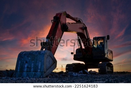 Excavator on earthmoving on sunset. Excavator dig ground at construction site. Dig foundation. Construction of residential building and renovation. Earthmover on groundwork. Building construction. 