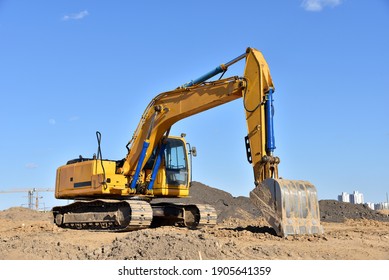 Excavator On Earthworks At Construction Site. Backhoe On Foundation Work And Road Construction. Heavy Machinery And Construction Equipment