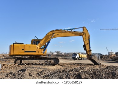 Excavator On Earthworks At Construction Site. Backhoe On Foundation Work And Road Construction. Heavy Machinery And Construction Equipment