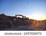 Excavator on sunset background. Open-pit mining. Backhoe dig ground in quarry. Heavy construction equipment on excavation on construction site. Excavator on groundwork on dramatic twilight. 