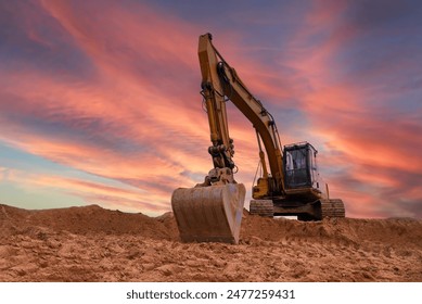 Excavator on sunset. Open-pit mining. Backhoe dig ground in quarry. Heavy construction equipment on excavation on construction site. Excavator on groundwork on dramatic twilight. Groundworks.