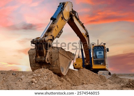 Excavator on sunset. Open-pit mining. Backhoe dig ground in quarry. Heavy construction equipment on excavation on construction site. Excavator on groundworks. Construction machinery on Earthworks.