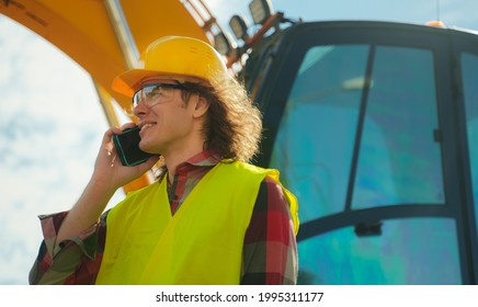 Excavator Operator In Hard Hat Talking By Smartphone.