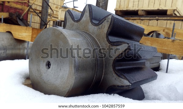 Excavator part. The gear\
is on the snow.