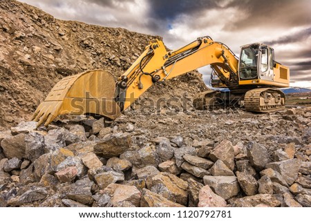 Excavator performing stone extraction work in an open pit stone mine