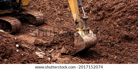 The excavator performs excavation work on the construction site. Crawler excavator digs in shale layer, excavator. Earth-moving equipment, Excavator work 