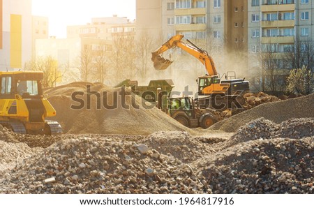 Excavator and screener machine working on construction site.