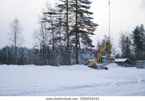 excavator in\
the snow on a construction site in\
winter