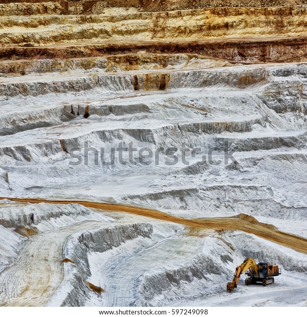 Excavator standing in a\
sand mine landscape