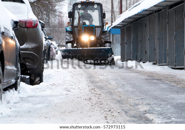 excavator and truck, clean the snow from roads and\
sidewalks in winter