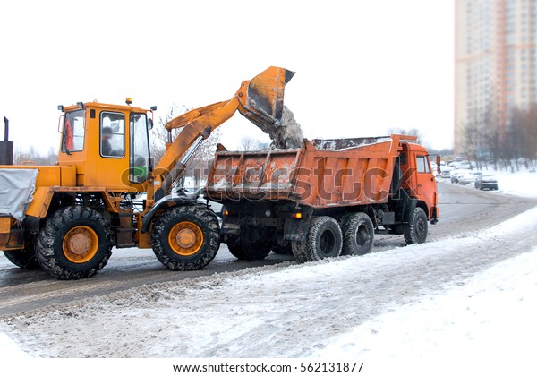 excavator and truck to clear snow from roads and\
sidewalks in winter