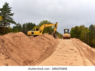 Excavator and Vibro Roller Soil Compactor at road construction and bridge projects in forest area. Heavy machinery for road work. Building a road works. Leveling and compaction of ground - Powered by Shutterstock