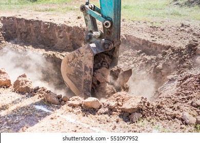 Excavator Working Digging A Trench.Construction Working With Excavator Tractor. Close-up Of A Construction Site Excavator.A Large Construction Excavation On The Construction Site In A Quarry.