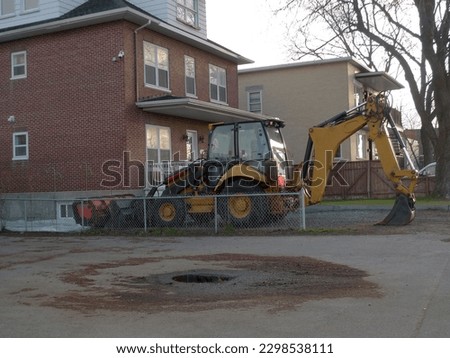 excavator working on a construction site in front of a house
