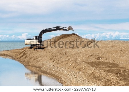 excavator works on the seashore
