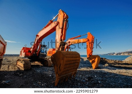Excavators working on earthmoving at construction of new embankment.
