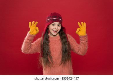 Excellent Weather. Winter Outfit. Cute Model Enjoy Winter Style. Little Kid Wear Knitted Hat. Stay Warm. Little Girl Winter Fashion Accessory. Small Child Long Hair Wear Hat Burgundy Background.
