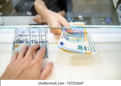 Exchange money, Exchange US dollar or American dollars (USD) for EUR money, A man and women are exchanging dollars for euros.