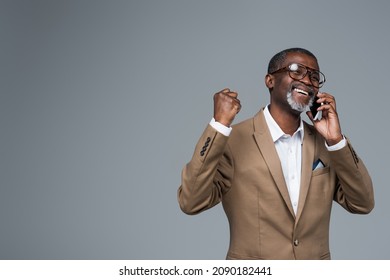 Excited African American Businessman Showing Success Gesture While Talking On Cellphone Isolated On Grey