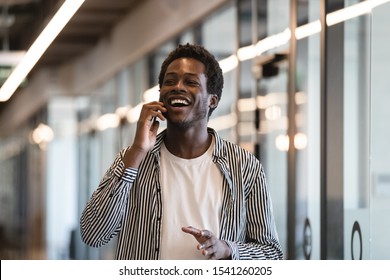 Excited African American Employee Talking On Phone, Get Job Or Promotion, Happy Smiling Businessman Standing In Modern Office Hallway, Using Cellphone, Receiving Good News, Emotional Reaction