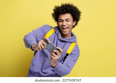 Excited African American man using smartphone playing mobile game celebration success isolated on yellow background. Overjoyed hipster shopping online, sports betting, win money - Powered by Shutterstock