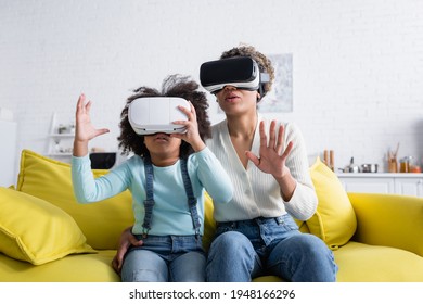 excited african american mom with daughter gesturing in vr headsets at home - Powered by Shutterstock