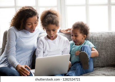 Excited African American Mom And Mixed Race Kids Looking At Laptop Surprised With Unbelievable Online News, Amazed Black Family Mother Children Astonished By Huge Shopping Sale Or Special Email Offer