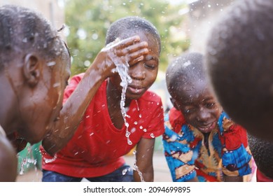 Excited African boys wash face with fresh water