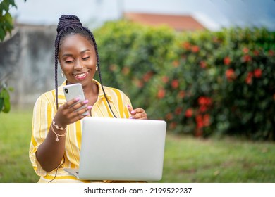 Excited African Lady With A Smart Phone And Laptop In A Garden