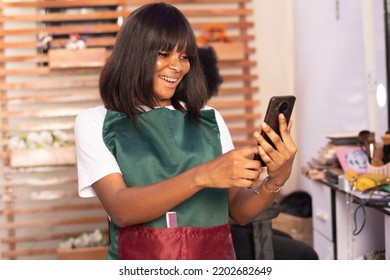 Excited African Makeup Artist Checking Her Phone