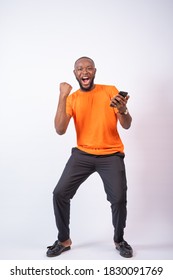 Excited African Man Celebrates While Holding His Phone