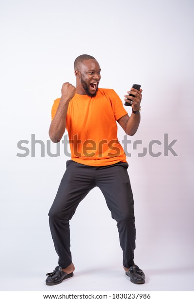 Excited African Man Celebrates While Looking Stock Photo Edit Now