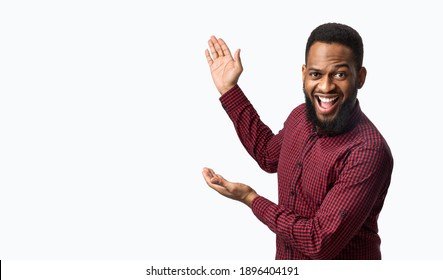 Excited African Man Showing Blank Space Aside Gesturing With Hands Standing Over White Background. Studio Shot. Look At This Great Offer Concept. Advertisement Banner - Powered by Shutterstock